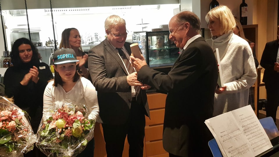 Surdada dal premi da la fundaziun Pestalozzi al president da l'uniun "Canorta Igniv" Gion Lechmann.
