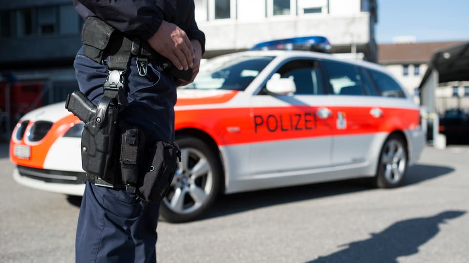 Maletg simbolic: polizist stat avant in auto da polizia dal Grischun