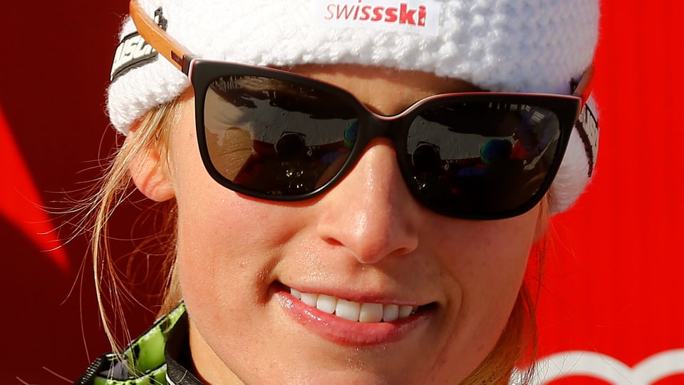 La skiunza Lara Gut cun egliers da sulegl gronds e chapitscha da Swissski.