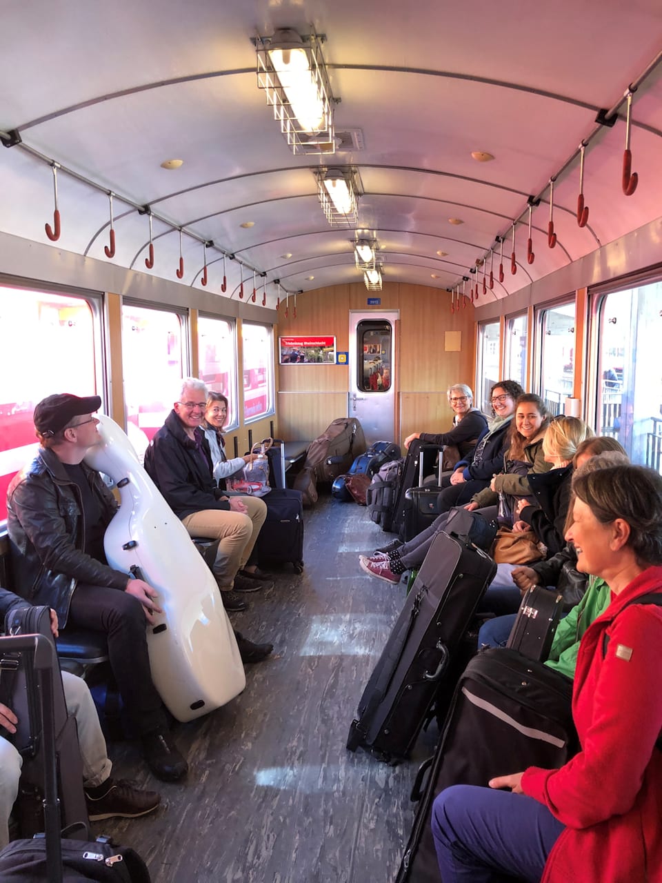 Orchesterleute der ORCHESTRINACHUR sitzen in einem Bahnwaggon