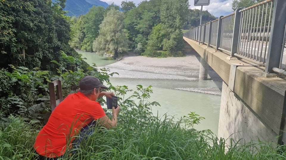 Eine Frau fotografiert eine Brücke.