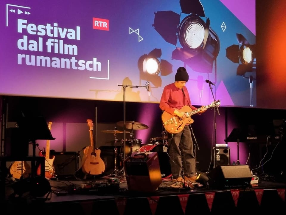 Künstler spielt Gitarre am Festival dal film rumantsch.