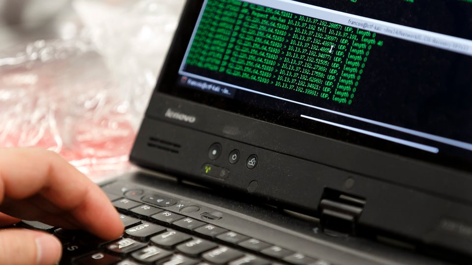 detagl dad in laptop, maun sin tastatura e text verd sin visur nair