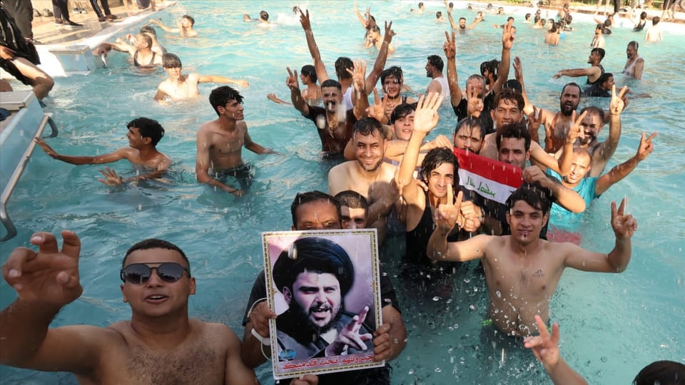 Aderents da Muktada al-Sadr en il bogn avert dal palazi da la regenza.