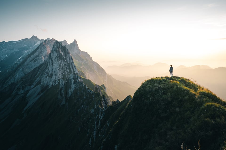 panorama da muntogna cun ina persuna sisum in piz