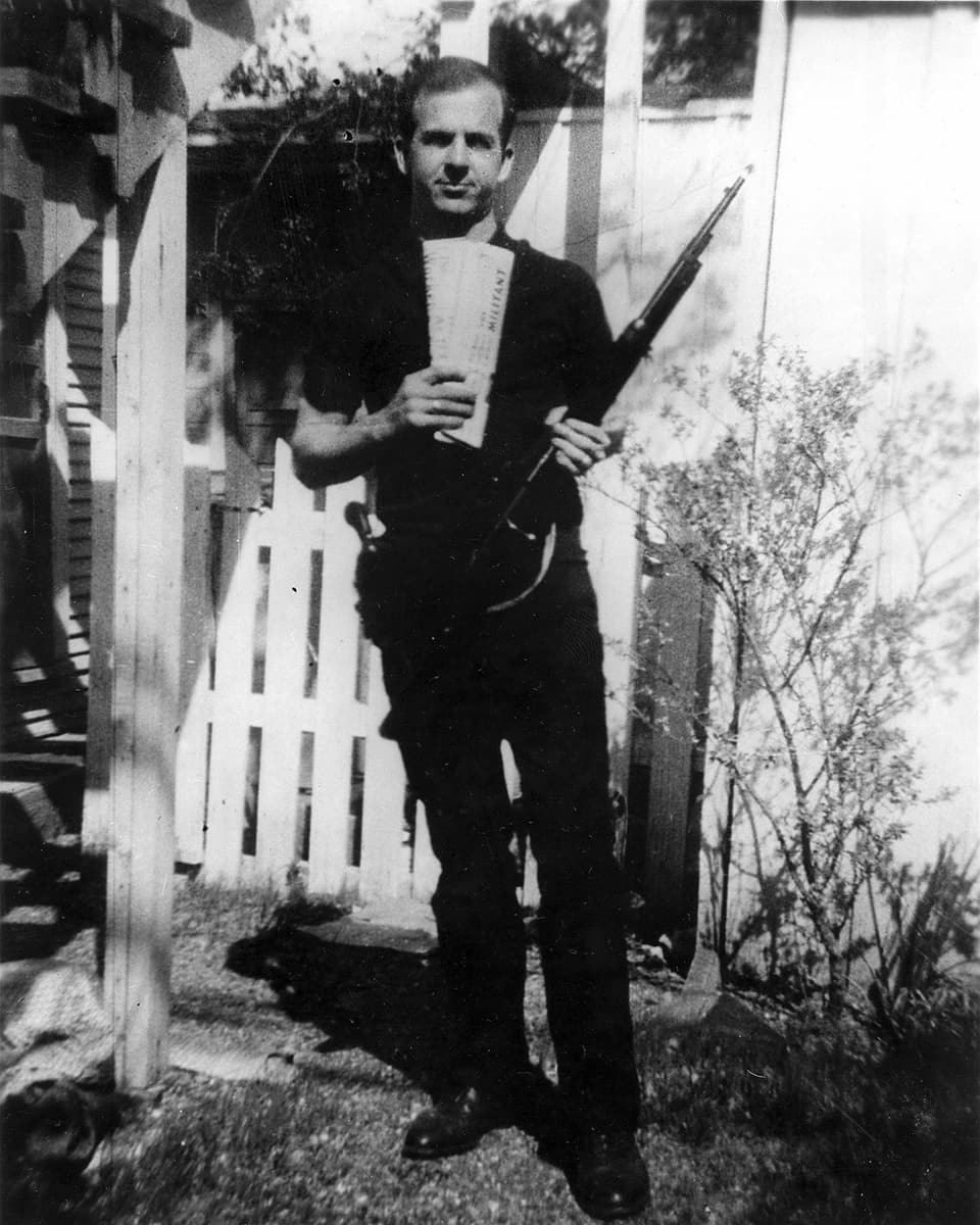 ina fotografia da l’assassin Lee Harvey Oswald cun duas gasettas marxisticas ed in schluppet che semeglia a quel, ch’era vegnì chattà suenter l’assassin. 