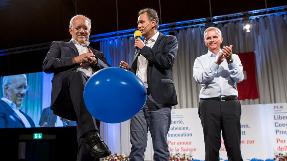 Ils cussegliers federals Johann Schneider-Ammann (sanester) e Didier Burkhalter (dretg) cun lur president da partida Philipp Müller a Surses.