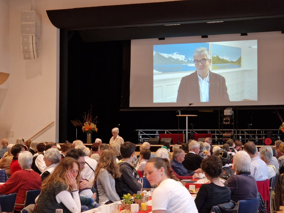 Auf der Leinwand wird ein Video von Jon Domenic Parolini eingespielt.