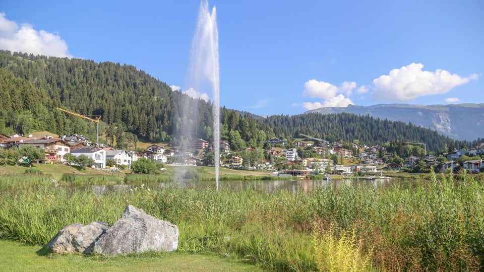 Il lai da Laax cun la fontauna che sprezza aua en l'aria.