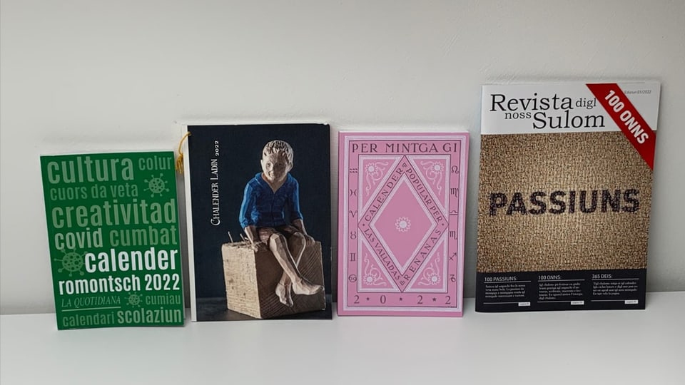 purtret dals quatter chalenders in dasper l'auter. In cun cuverta verda, in cun naira, in rosa ed in brin. 