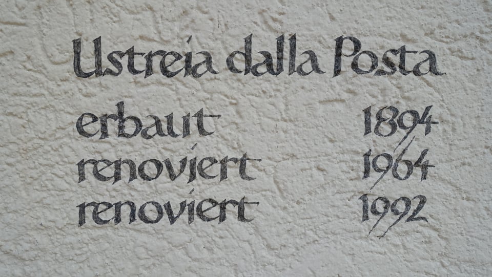 Inscripziun en la paraid che descriva cura che l'hotel è vegnì bajegià (1894), cun duas renovaziuns.