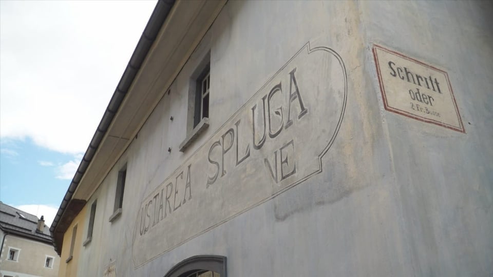 purtret da la front da la chasa nua ch'ins vesa l'inscripziun dal num sin ina paraid grischa.