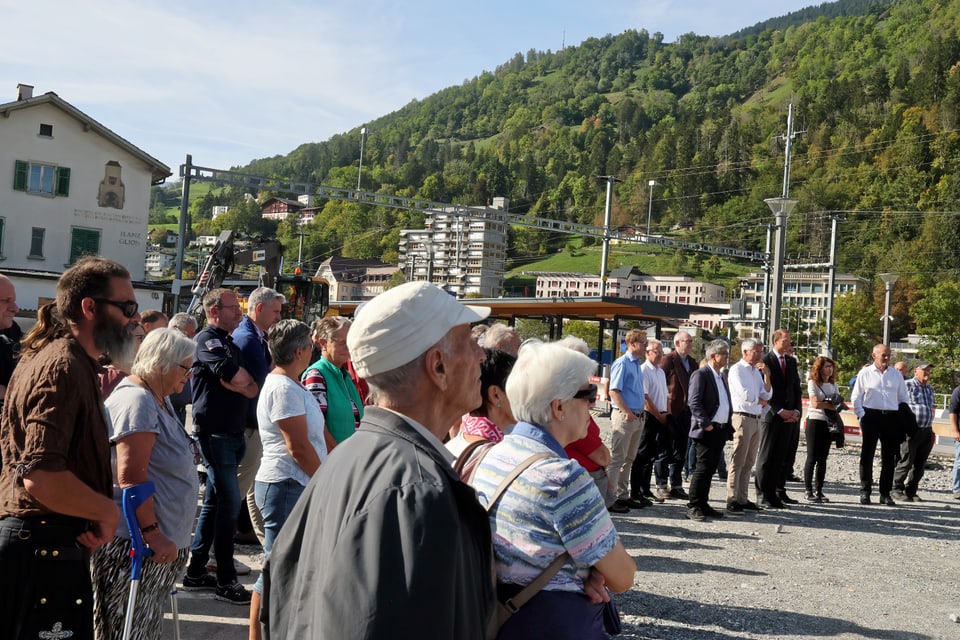 Menschenmenge lauscht einer Rede auf dem Bahnhofplatz Ilanz.