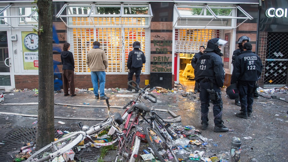 policists e glieud avant stizuns e velos demolids en ina via a Hamburg