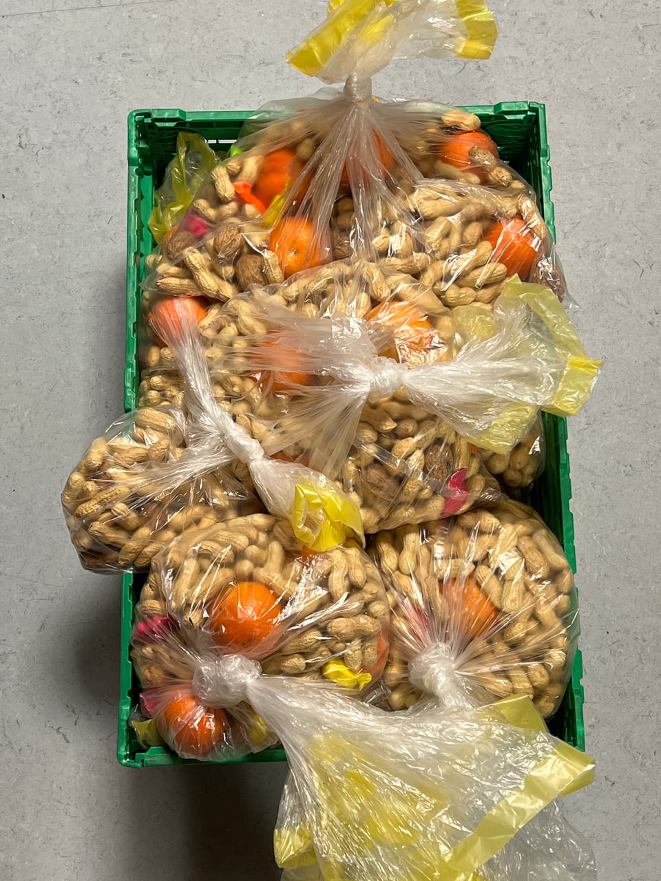 Eine Kiste mit Säcken voller Mandarinen und Nüsschen