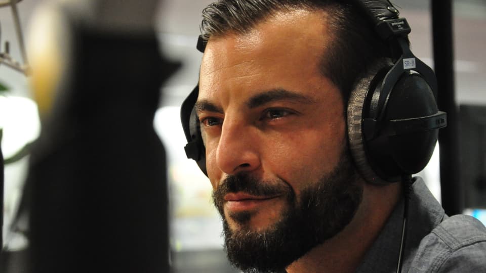 Bligg, in um cun barba avant il microfon en il studio da RTR