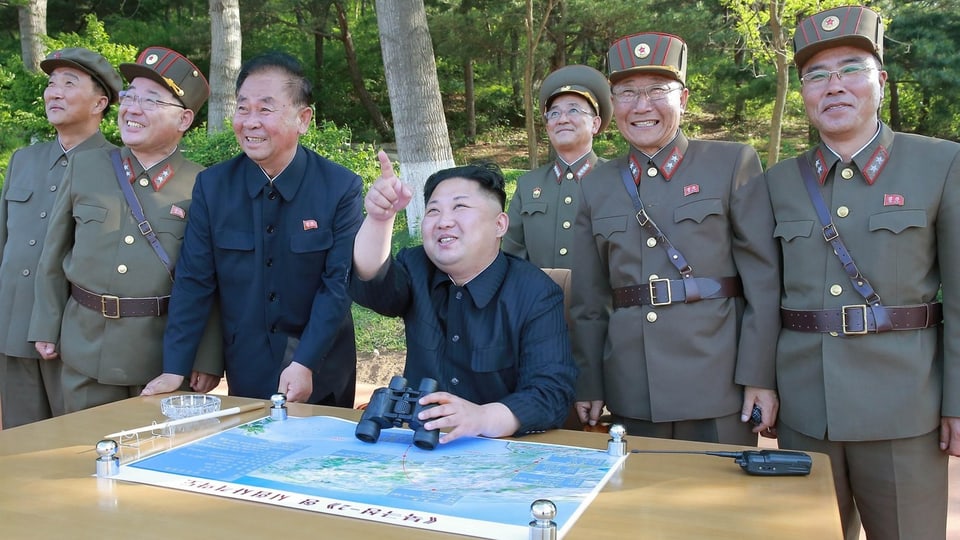 Kim sesa, ils auters sis en uniforma stattan en pe. Tuts guradan da quai cuntents.