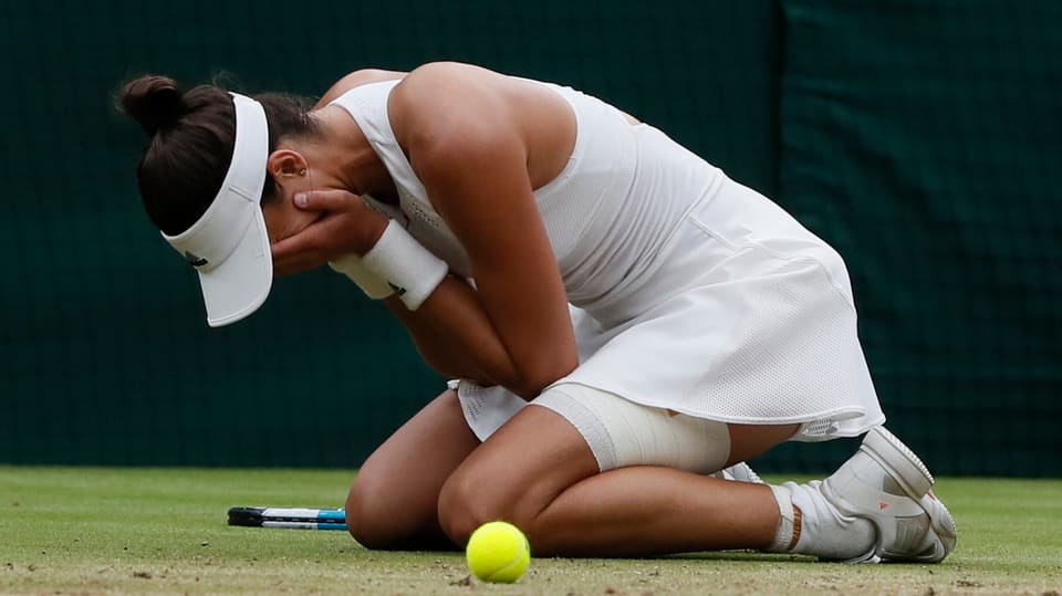 Giugadra da tennis cun mauns davant la fatscha.