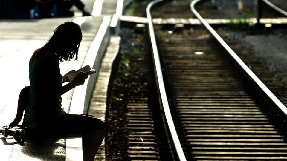 Persuna spetga a la staziun da Losanna sin il proxim tren.