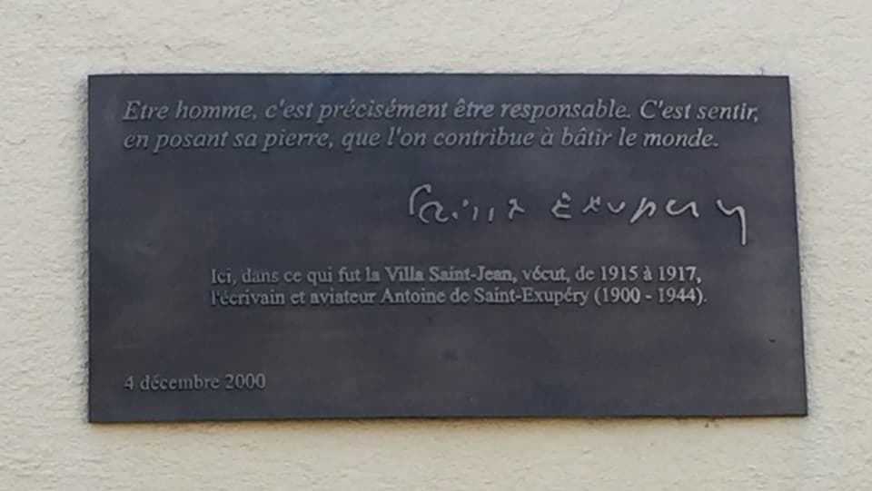 In onur ad 	Antoine de Saint-Exupéry sa ha mess vi da la chasa ina tavla commemorativa.
