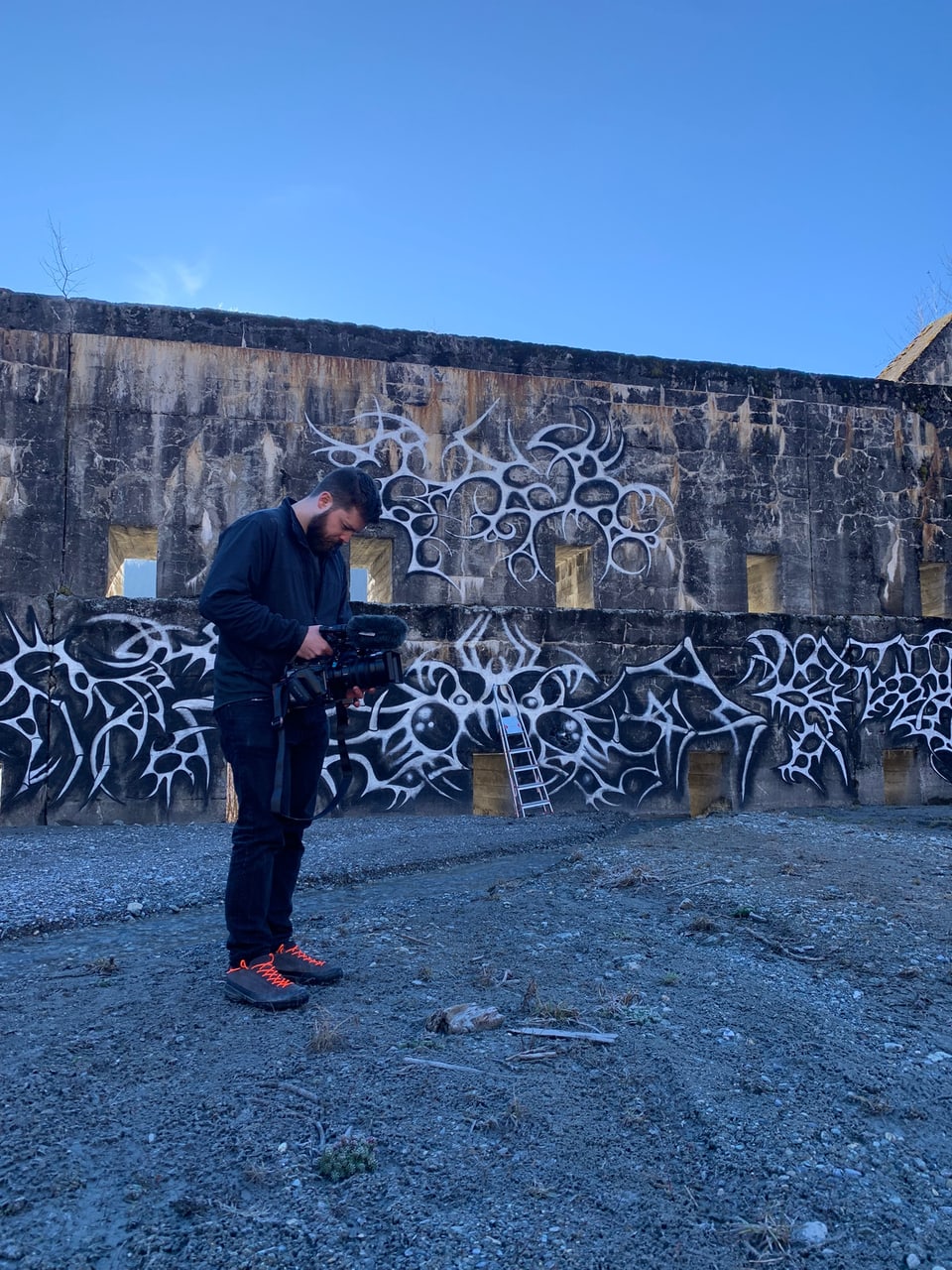 Kameramann vor Graffiti-Wand