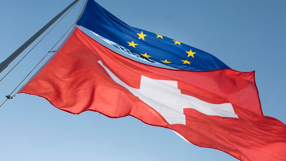 Las bandieras da la Svizra e l'UE en il vent.