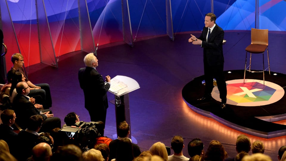 David Cameron sin tribuna e glieud che taidla tiers