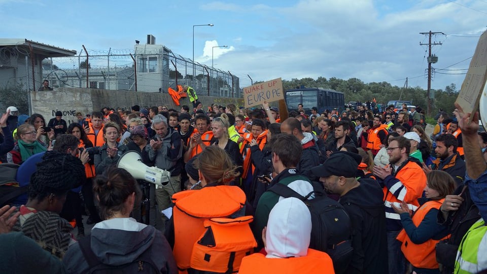 In'acziun da protest da voluntaris e sustegniders davant il champ a Moria, ils 24 da mars 2016.