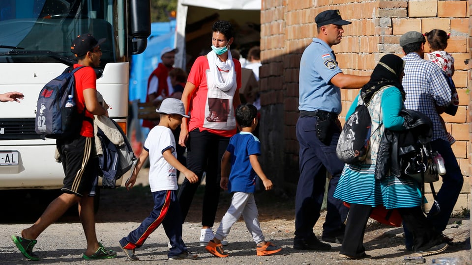Migrants èn sin via al biro da registraziun datiers da Novarnik en la Croazia da l'ost.