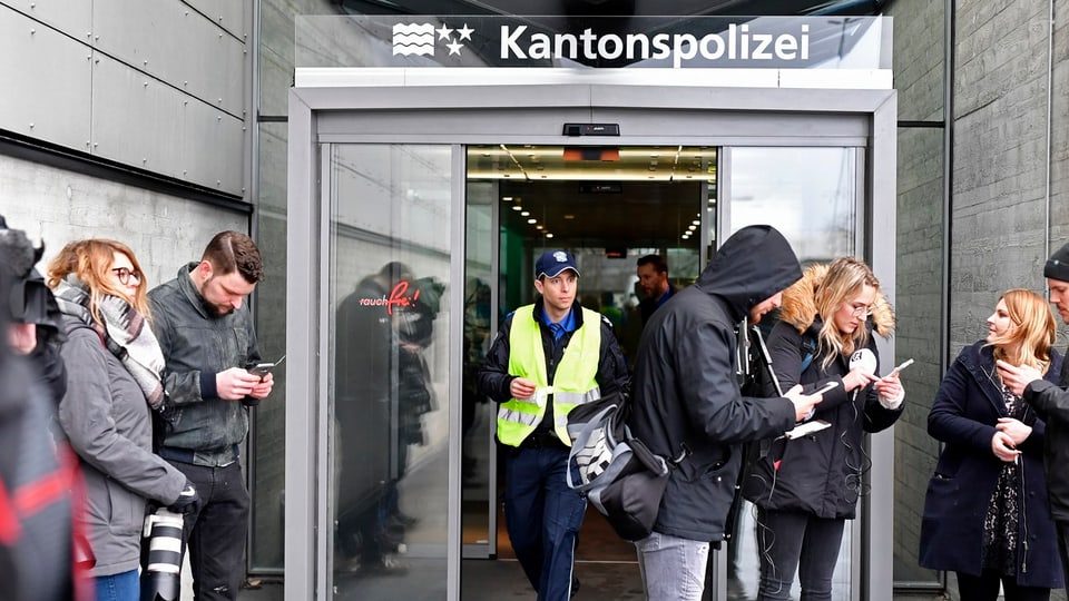 Persunas da medias davant l'isch da la polizia chantunala da l'Argovia a Schafisheim