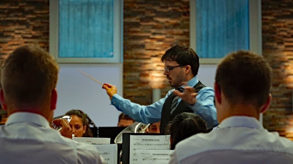 Il dirigent da la musica giuvenila Grischun central durant lur preschentaziun