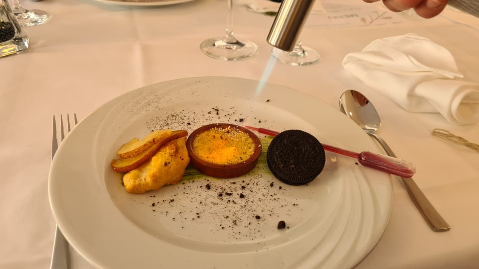 Ein Dessert wird am Tisch fertig zubereitet.