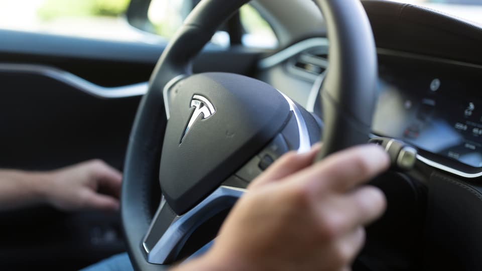 Logo Tesla vid la roda da l'auto.