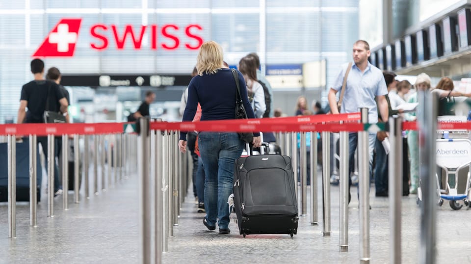 Passagiers tar il chek-in.