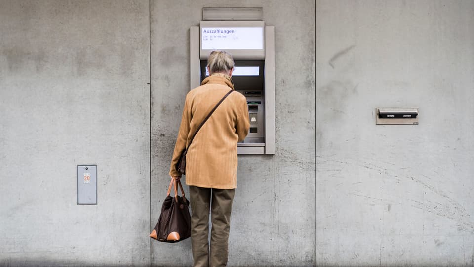 Purtret d'ina dunna vid in automat da banca. 