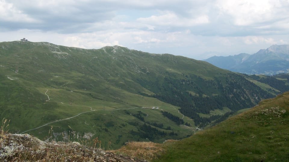 Vista da la Fuorcla da Ranasca sin il cunfin da l’alp da Siat sin l’alp da Ruschein e sin la staziun da la pendiculara dal Crap Masegn.