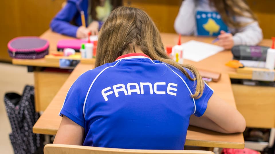 scolar cun in t-shirt che ha scrit «France»