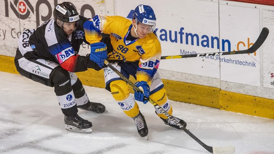 Dus giugaders da hockey che cumbattan per il puck.