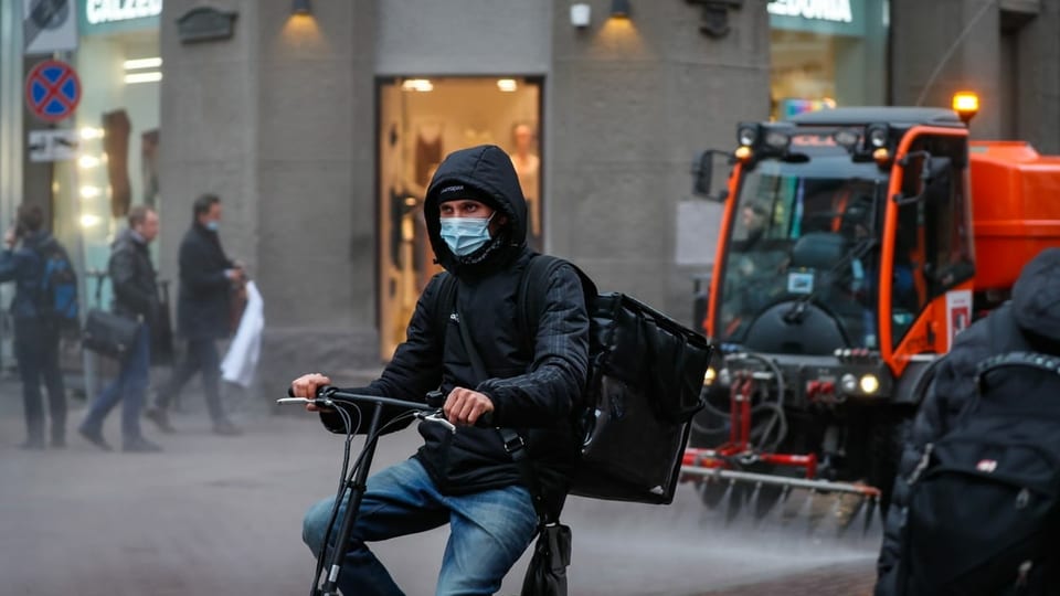 purtret d'in  um sin in velo che passa tras ina citad. 