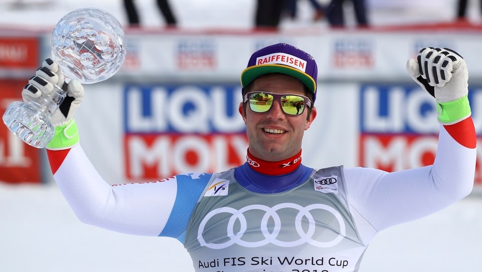 Il skiunz Beat Feuz tegn en maun la culla da cristal pitschna.