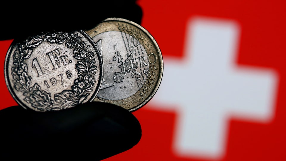 Maletg simbolic - in maun nair tegna in euro ed in franc - davostiers hai la vopna svizra