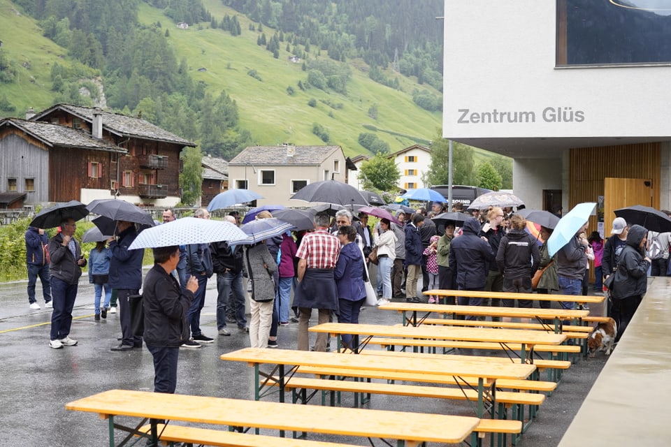 Die Gäste des kantonalen Jugendmusikfests warten im Regen vor dem Konzertsaal in Vals.