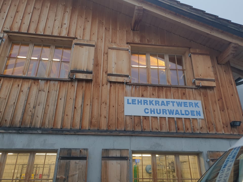 Ina chasa da lain e betun cun si ina plachetta alv-blaua «Lehrkraftwerk Churwalden»