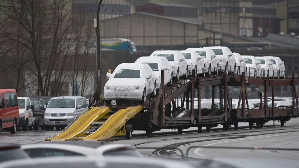 Autos novs protegids cun ina cuverta sin in char da tren.
