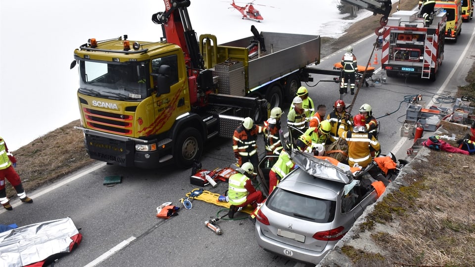 Purtret da l'auto ed il crap sisu, ils pumpiers èn vid liberar ina persuna. 