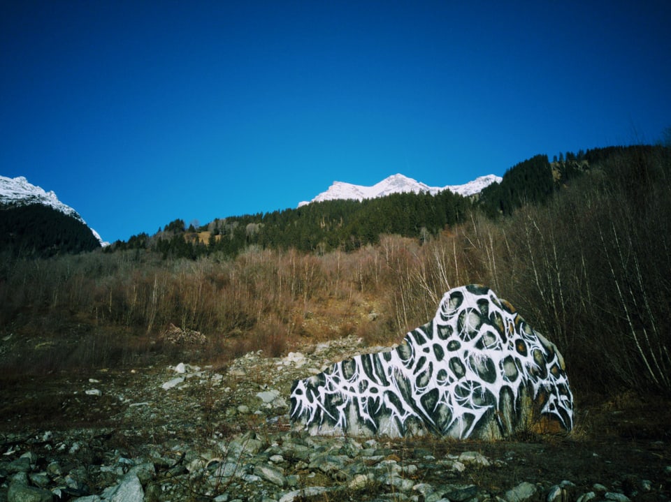 Stein mit Graffiti, in Berglandschaft