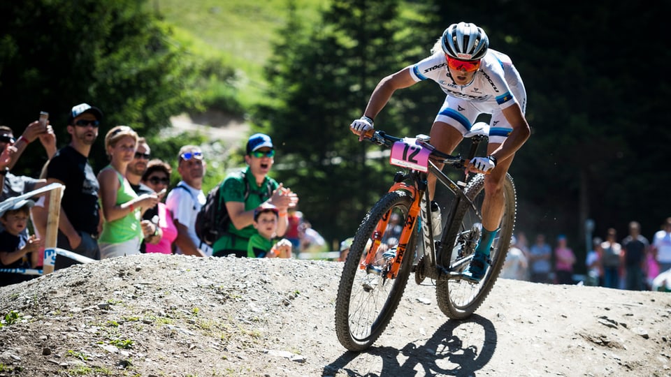 Jolanda Neff sin in mountainbike sin ina via alpestra. Davostiers public che applaudescha.