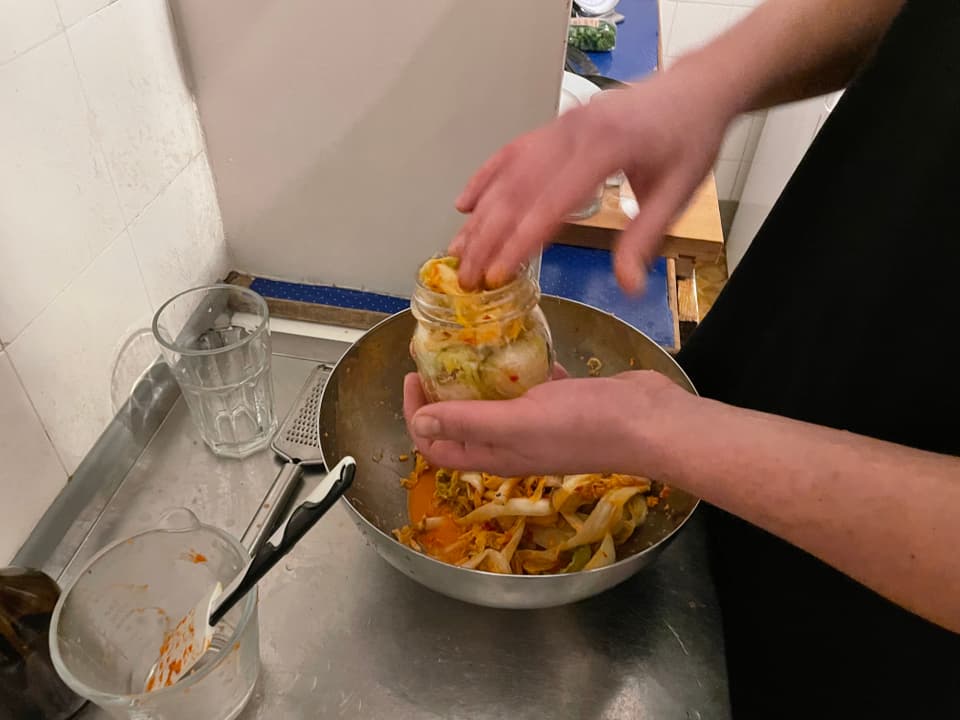 Das Konservenglas wird mit Kimchi randvoll gefüllt.