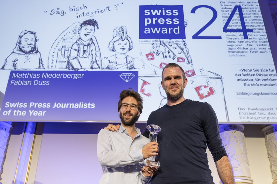 Zwei Männer mit einem Pokal auf der Bühne bei der Swiss Press Award Veranstaltung.