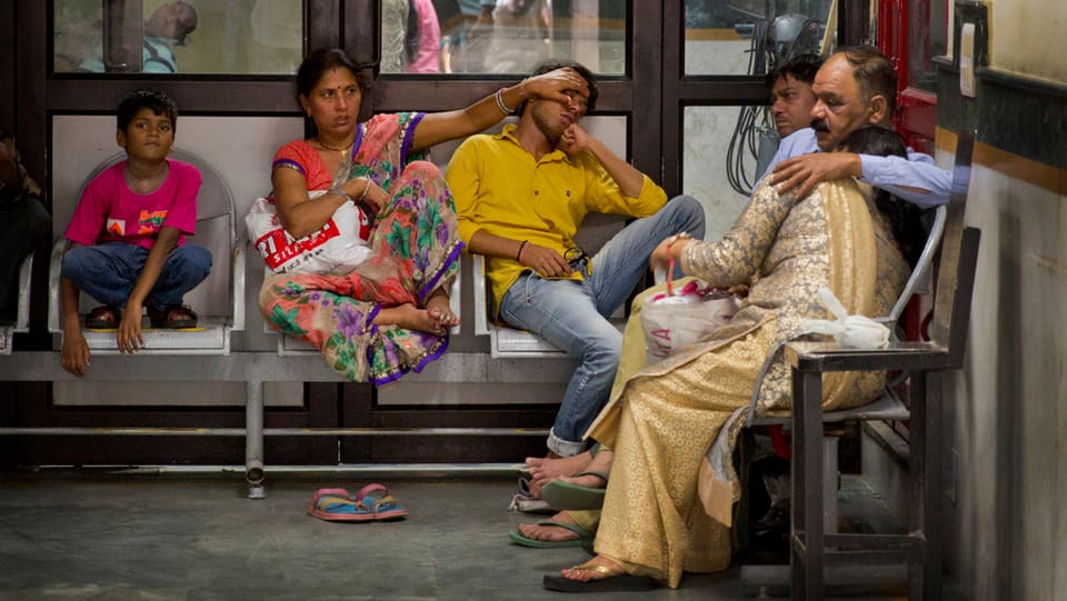 Pazients da malaria spetgan cun auta fevra en la sala da spetga d'in ospital a New Dehli.
